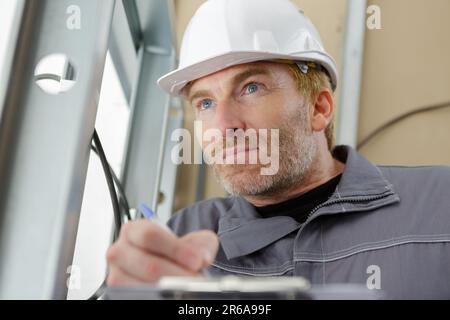 senior electrician concentrating on wiring Stock Photo