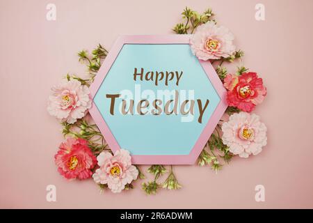 Happy Tuesday typography text decorate with flower on pink background Stock Photo