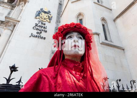 London, UK. 8 June, 2023. The Red Rebel Brigade mime troupe join opponents of a proposed scheme to drill for gas in Surrey rallying outside the Royal Courts of Justice at the start of a judicial review. The original application to search for fossil fuels in 2020 was rejected by Surrey County Council, but later approved by minister Michael Gove. Waverley Borough Council challenged this decision and were granted a judicial review. Arguments raised include greenhouse gas emissions and the proximity of the site to an Area of Outstanding Natural Beauty (AONB). Credit: Ron Fassbender/Alamy Live News Stock Photo