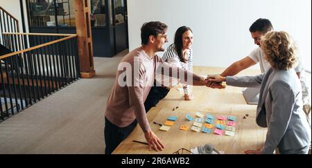 business team stacking hands together in a meeting. Advertising professionals motivating each other in an office. Group of business people working tog Stock Photo