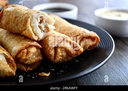 Egg rolls on a black plate Stock Photo