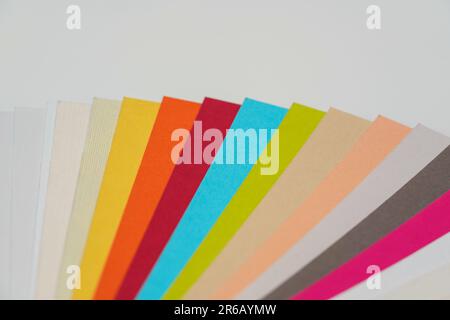 Colourful paper swatches on white desk, closeup detail Stock Photo