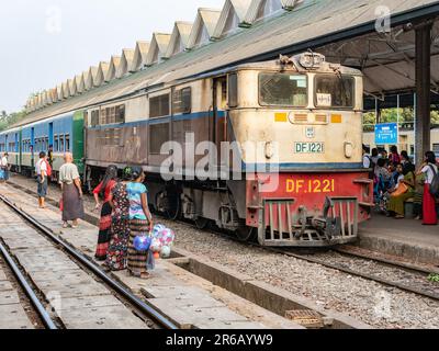 Passenger train and passengers waiting at Yangon Central, the main railway station in Yangon, Myanmar. Stock Photo