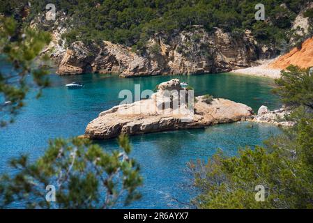 People sunbathe on Galley rock or Submarine rock. View  from hiking path near Calanque de Port d'Alon (between Saint-Cyr-sur-Mer and Bandol), France. Stock Photo