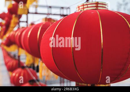 An array of vibrant red Chinese lanterns are suspended from the ceiling during the Chinese New Year Stock Photo