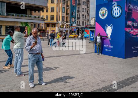 Ankara, Turkey. 08th June, 2023. A man poses for a photo in front of the 2023 UEFA Champions league billboard at Taksim Square. Manchester City and Inter Atatürk will meet at the Olympic Stadium in the final match, which will be held for the 68th time in total, which will determine the champion of the 2022-23 UEFA Champions League season. Within the scope of the events organized, a giant Champions League cup and a model of the soccer ball to be used in the specially designed match were shown in Taksim, the most popular square of Istanbul. Credit: SOPA Images Limited/Alamy Live News Stock Photo