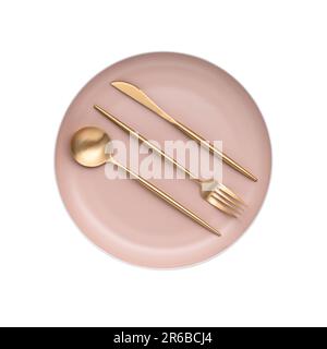 Golden cutlery on beige plate. The object is isolated on a white background. View from above. Flat lay design. Top view. Table knife, fork and spoon. Stock Photo