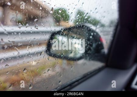 Car windows filled with water droplets due to the great storm falling on the city. Stock Photo