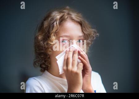 Child with swollen pink eye. Eyes infection and pollen allergy. Allergic little boy with runny nose and red eyes. Sick kid at doctor or hospital. Stock Photo