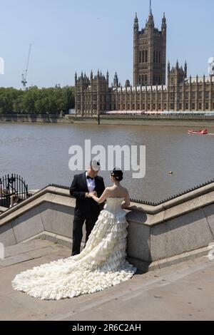 Chinese newly wed couple having their wedding photograph taken opposite the Houses of Parliament, Westminster, London, England, UK Stock Photo