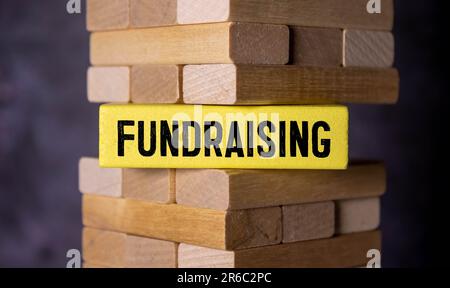 Question concept. On the table are cubes with questions and a red plaque with the inscription - Fundraising. Stock Photo