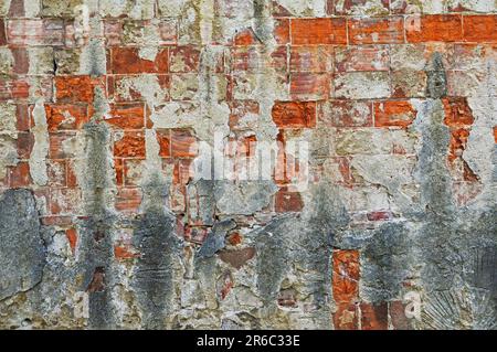 An old brick wall with cracked and chipped plaster Stock Photo