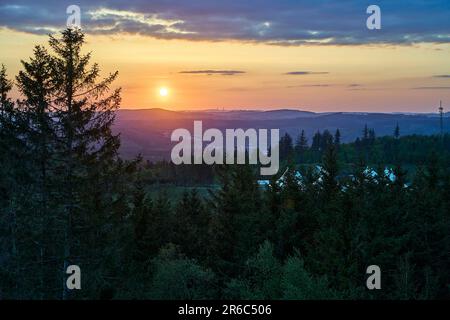 Skilift in front of a sunset over the mountain range of the Rothaargsteig close to Luetzel in Germany. Stock Photo