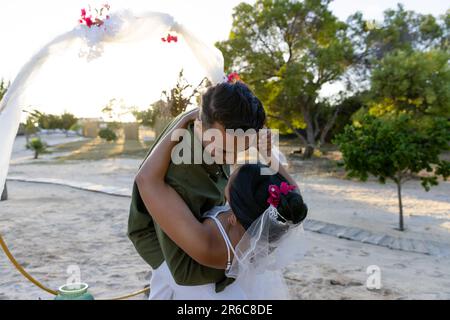 Caucasian newlywed couple dancing at wedding ceremony at beach during sunset Stock Photo