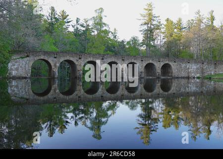 Historic stone bridge reflecting in lake in Cumberland Mountain State Park Stock Photo