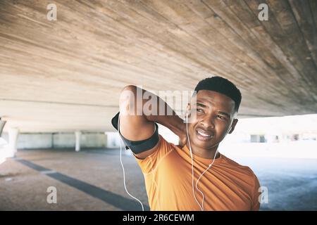 Pain is a call to pause. a young man experiencing neck pain while working out against an urban background. Stock Photo