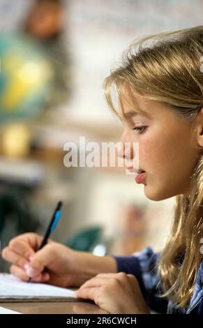 middle school student completes an assignment in class Stock Photo