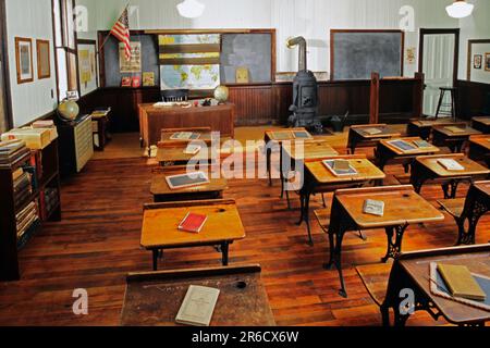 19th century classroom with wooden desks, a coal burning stove and vintage textbooks located in Alabama town USANo Stock Photo