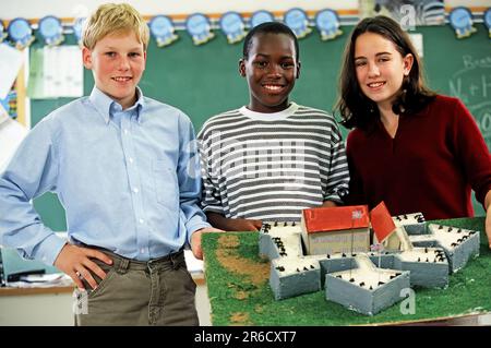 Three mixed race High school students probably display their class project Stock Photo