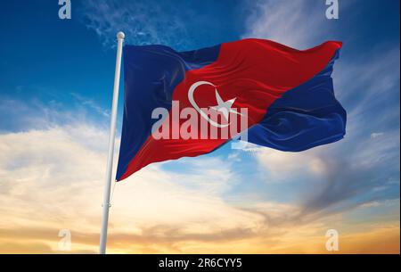 official flag of Kluang, Johor Malaysia at cloudy sky background on sunset, panoramic view. Malaysian travel and patriot concept. copy space for wide Stock Photo