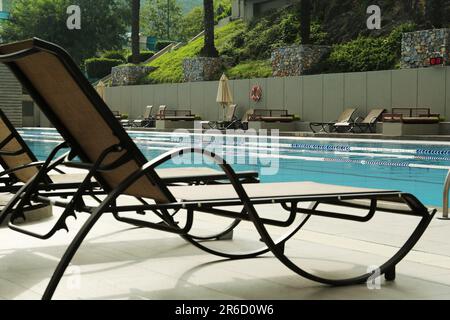 Sunbeds near swimming pool at luxury resort Stock Photo