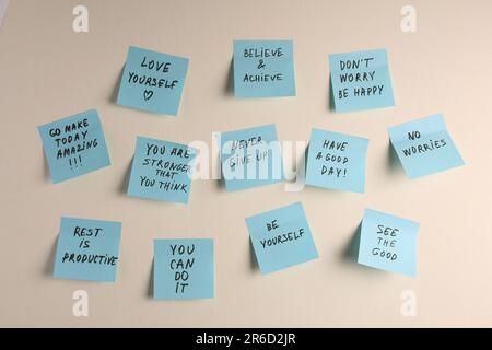 Paper notes with life-affirming phrases on white wall Stock Photo