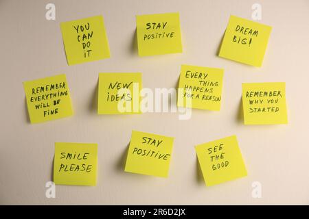 Paper notes with life-affirming phrases on white wall Stock Photo