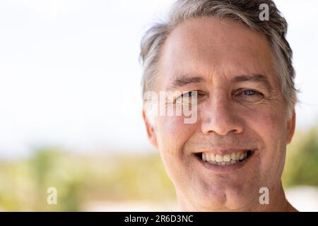 Close-up portrait of handsome caucasian senior man smiling and looking at camera, copy space Stock Photo