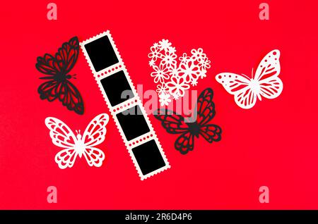 Cinema strip photo paper frames with butterfly paper on red background. Save clipping path. Stock Photo