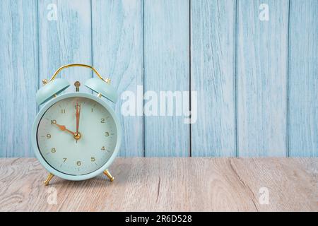 Vintage retro alarm clock ten time 10 o'clock on table wood with dark background. Stock Photo