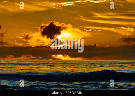 Sunset red clouds over the coast line. Stock Photo