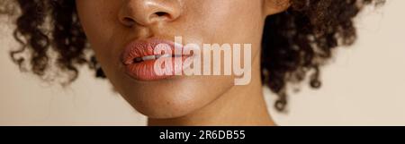 Female model with natural makeup posing on beige background Stock Photo