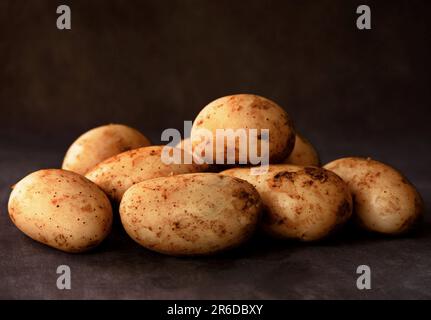 Raw potatoes on black background Stock Photo