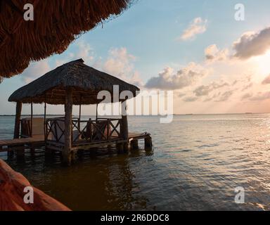 wooden dock with thatched roof, traditional Mexican design in the summer sunset with the lake of Old Town city in the background without boats, no peo Stock Photo