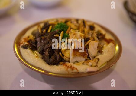 Loaded Hummis with Beef and chicken with pine nuts Stock Photo