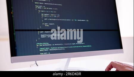 Computer Programmer Writing Program Code On Computer In Office Stock Photo