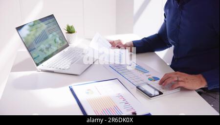 Business Accountant Using Finance Chart Document And Calculator Stock Photo