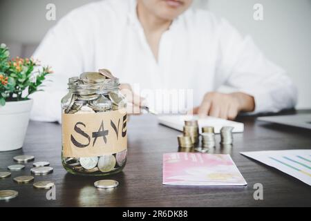 a woman makes calculations, checks her finances, makes notes in a notebook and sets aside some of the funds Stock Photo