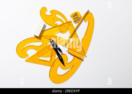 Close up of yellow rulers, compass and sharpener on white background ...