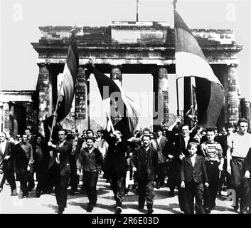 FILED - 17 June 1953, Berlin: East Berliners march through the Brandenburg Gate with flags waving from the East Sector. On June 17, 1953, a million people in the GDR protested against the still young socialist state - until Soviet tanks ended the uprising. Dramatic days. (to dpa 'When the tanks rolled: 70 years after the popular uprising in the GDR') Photo: dpa Stock Photo