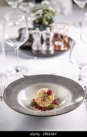 Fancy wedding dessert from white chocolate, almonds and coconut with raspberries on a deep plate. Stock Photo