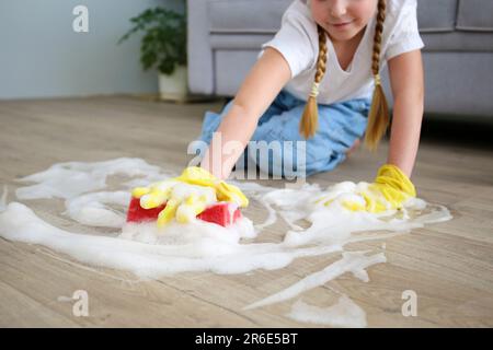 The child washes the floors of the house. The concept of child labor. The assistant. Stock Photo