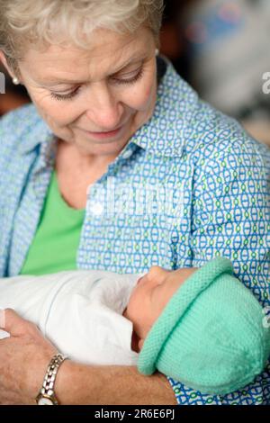 A woman holds a newborn baby girl the day after she was born. Stock Photo