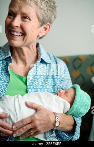 A woman holds a newborn baby girl the day after she was born. Stock Photo