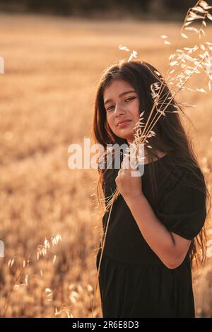 teenage girl in a black dress, Asian, nature, wheat field Stock Photo
