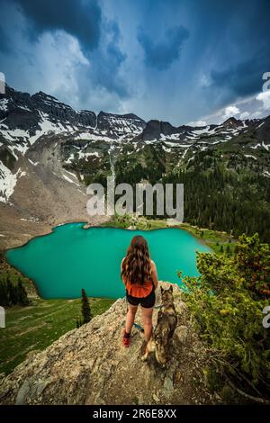 Woman and Dog overlooking a Stormy Blue Lakes near Telluride, Colorado Stock Photo