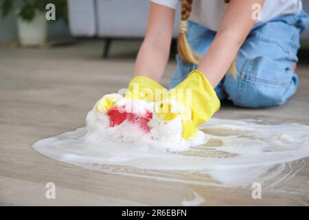 The child washes the floors of the house. The concept of child labor. The assistant. Stock Photo