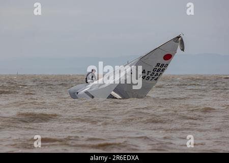 Righting a capsized dinghy on a choppy sea Stock Photo