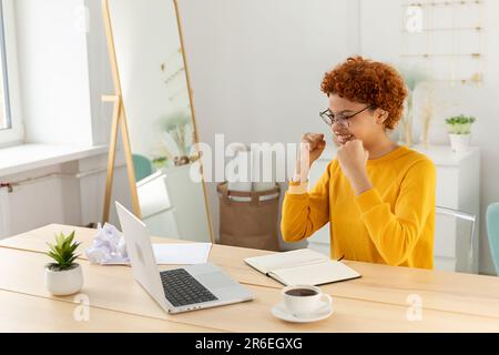Excited happy african american woman euphoric winner. Girl student looking at laptop passed exam reading great news getting good result winning online bid feeling amazed at home. Winning gesture Stock Photo