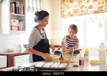 Mother, cooking or girl baking in kitchen as a family with a young kid learning cookies recipe at home. Cake pastry, baker or happy mother helping or Stock Photo
